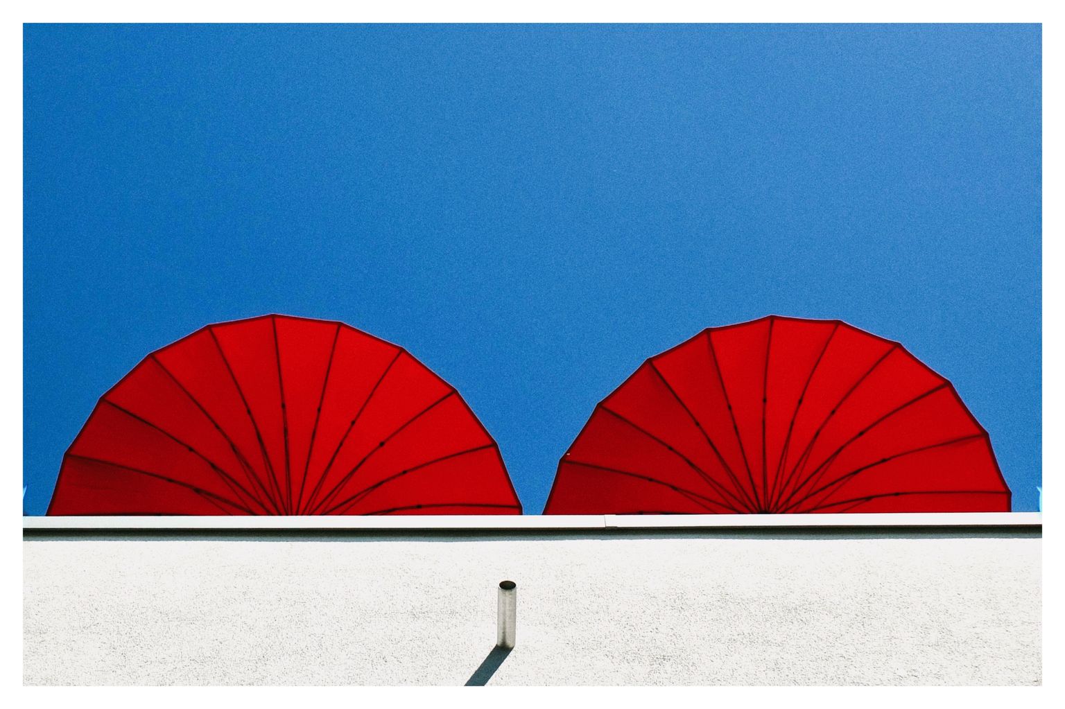 Zwei rote Sonnenschirme vor Blau (176/365)
